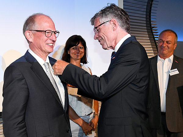 Feierlicher Moment: Hauptgeschäftsführer Thomas Hoefling (r.) steckt Kammerpräsident Rainer Reichhold (l.) im Juni 2018 die Goldene Ehrennadel an.