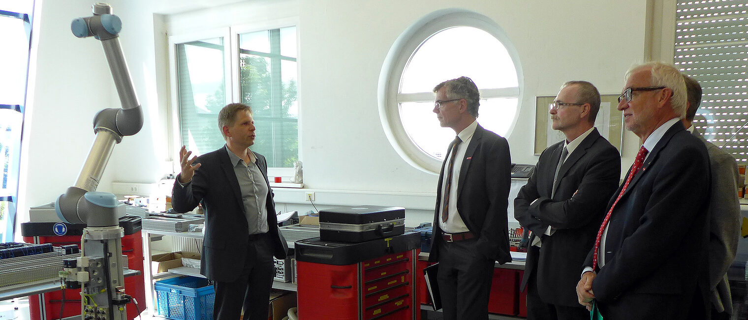 Dirk Thamm, Geschäftsführer der Faude Automatisierungstechnik, erklärt Thomas Hoefling, Norbert Durst und Claus Munkwitz die Einsatzmöglichkeiten der mobilen Roboter. (Personen v.l.n.r.)