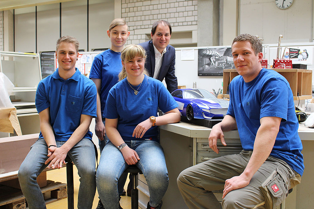 Preisträger im Landkreis Göppingen: Beuttenmüller Design + Engineering Center, Uhingen"Unser Betrieb ist eigentlich perfekt für den Preis: Die Ausbildung ist ab dem ersten Tag sehr strukturiert, vor Prüfungen wird an Schwächen gearbeitet und auch die Meisterschule wird unterstützt. Es ist cool, alle Abteilungen kennenzulernen, so ist man schnell mittendrin. Bei Projekten wie unserer Designstudie dürfen wir uns auch mal kreativ austoben. Die älteren Kollegen geben ihre Erfahrung gerne weiter, und Fehler zu machen ist hier kein Problem, solange wir offen damit umgehen."V.l.n.r.: Simon Franz, 20 Jahre, 4. Lehrjahr, Jana Haidle, 20 Jahre, 1. Lehrjahr, Natalie Mayer, 17 Jahre, 1. Lehrjahr, Harald Schnaible, 27 Jahre, Ausbildungsmeister und ehemaliger Azubi zum technischen Modellbauer. Hinten: Geschäftsführer Jens Beuttenmüller. Preisträger im Landkreis Göppingen: Beuttenmüller Design + Engineering Center, Uhingen"Unser Betrieb ist eigentlich perfekt für den Preis: Die Ausbildung ist ab dem ersten Tag sehr strukturiert, vor Prüfungen wird an Schwächen gearbeitet und auch die Meisterschule wird unterstützt. Es ist cool, alle Abteilungen kennenzulernen, so ist man schnell mittendrin. Bei Projekten wie unserer Designstudie dürfen wir uns auch mal kreativ austoben. Die älteren Kollegen geben ihre Erfahrung gerne weiter, und Fehler zu machen ist hier kein Problem, solange wir offen damit umgehen."V.l.n.r.: Simon Franz, 20 Jahre, 4. Lehrjahr, Jana Haidle, 20 Jahre, 1. Lehrjahr, Natalie Mayer, 17 Jahre, 1. Lehrjahr, Harald Schnaible, 27 Jahre, Ausbildungsmeister und ehemaliger Azubi zum technischen Modellbauer. Hinten: Geschäftsführer Jens Beuttenmüller.