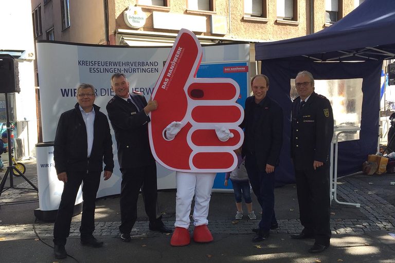 Karl Boßler (Kreishandwerksmeister und Obermeister der Innung des Kraftfahrzeuggewerbes Nürtingen-Kirchheim u. T., Dettingen u. T.), Alfred Bidlingmaier (Stv. Vorsitzender des Kreisfeuerwehrverbandes Esslingen-Nürtingen, Jens Schmitt (Geschäftsführer der Kreishandwerkerschaft Esslingen-Nürtingen) und Bernd Müller (Vorsitzender des Kreisfeuerwehrverbandes Esslingen-Nürtingen) mit Maskottchen "Karle".