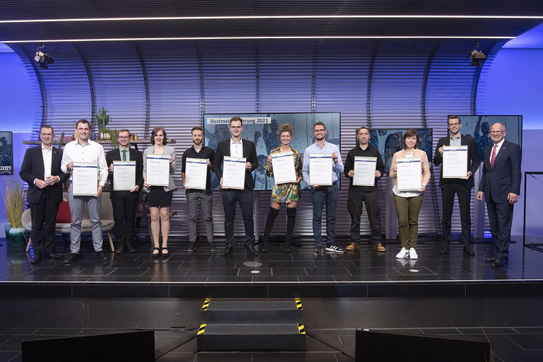 Die Bestmeisterinnen und Bestmeister 2021 mit Vizepräsident Alexander Kotz (1.v.l.) und Präsident Rainer Reichhold (1.v.r.) beim gemeinsamen Abschlussfoto auf der Bühne im Forum der Handwerkskammer.