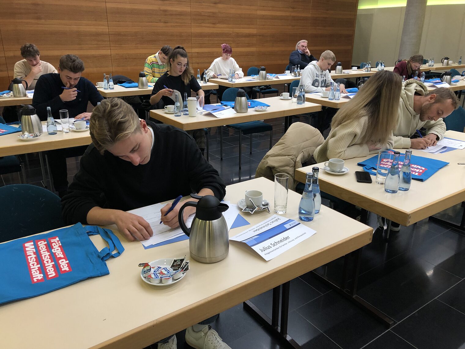 Die jungen Handwerkerinnen und Handwerker beim Unterzeichnen ihrer Verträge.