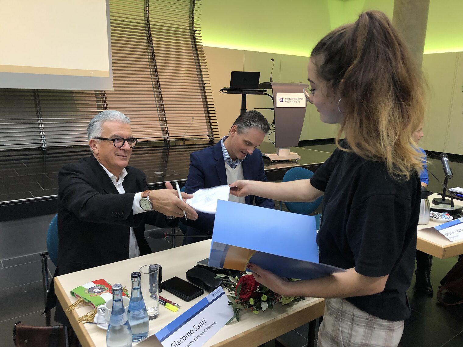 Die Müllheimer Malerin und Lackiererin Celina (r.) erhält ihren Vertrag von Bürgermeister Giacomo Santi aus Volterra.