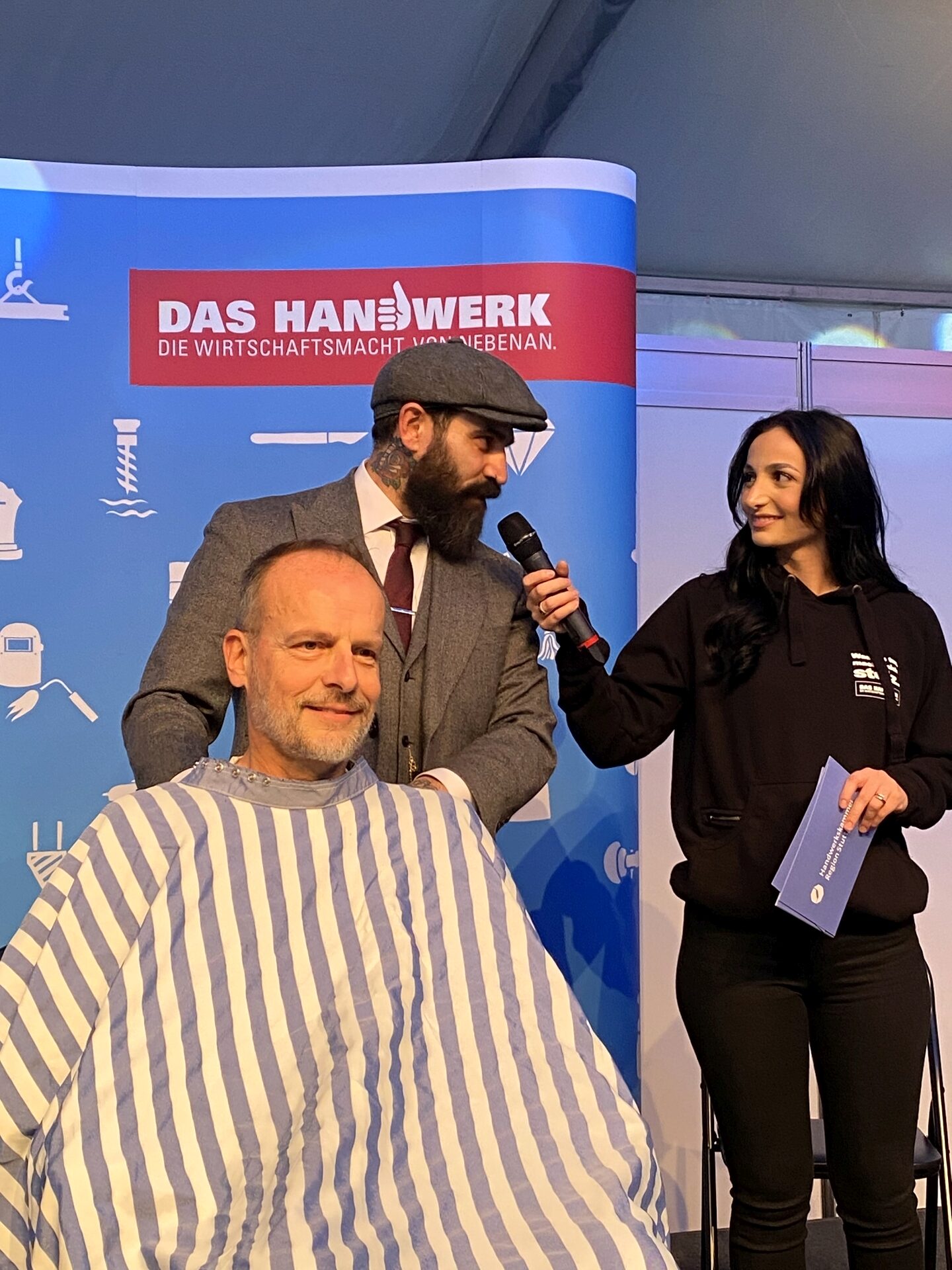 Der Stuttgarter Barbier Ioannis Chronakis zeigte sein Handwerk auch auf der Showbühne - hier im Gespräch mit Handwerkskammer-Moderatorin Erza, die durch den Abend führte.